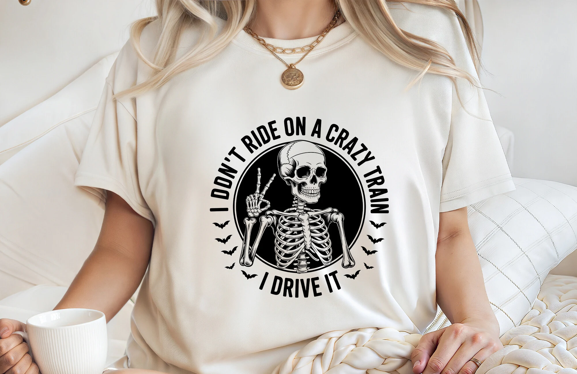 I Don't Ride on a Crazy Train I Drive It Halloween SVG featuring bold arched black text, a skeleton making a peace sign, and small bat silhouettes.